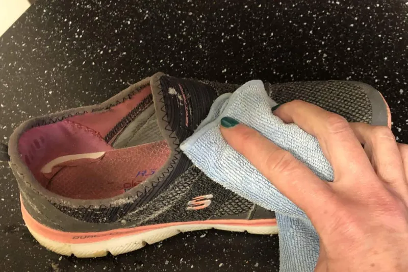 Dabbing the outside of the shoe with a microfibre cloth to remove the soap