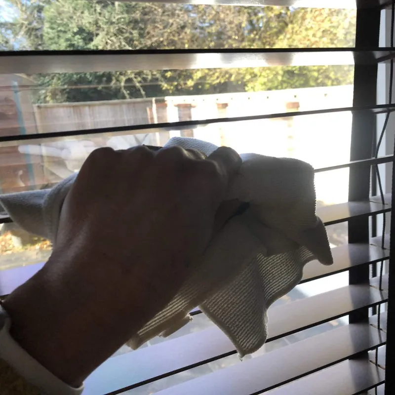 Cleaning a greasy Venetian blind with a microfiber cloth