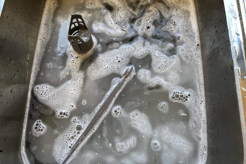 dishwasher filter in soapy water in the sink