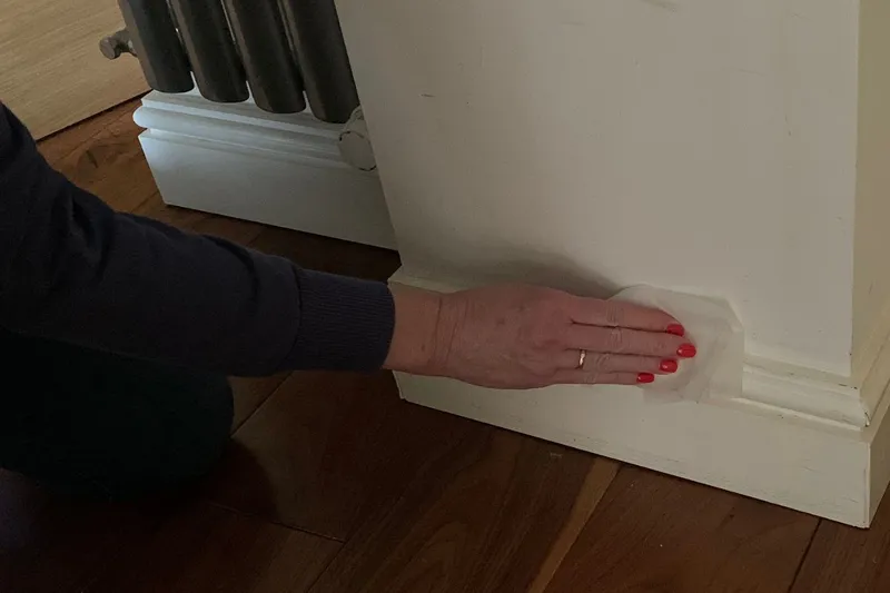dusting baseboards with a dryer sheet