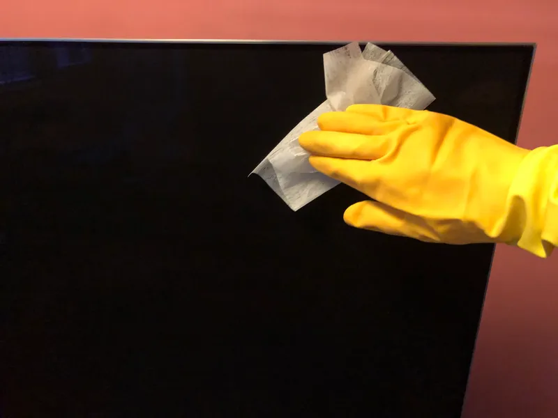wiping a tv screen with a dryer sheet