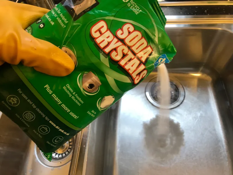 pouring soda crystals into hot water