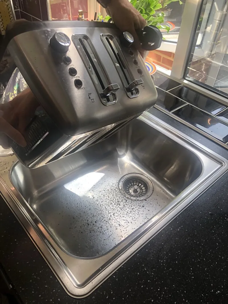 shaking the toaster upsidedown into the sink