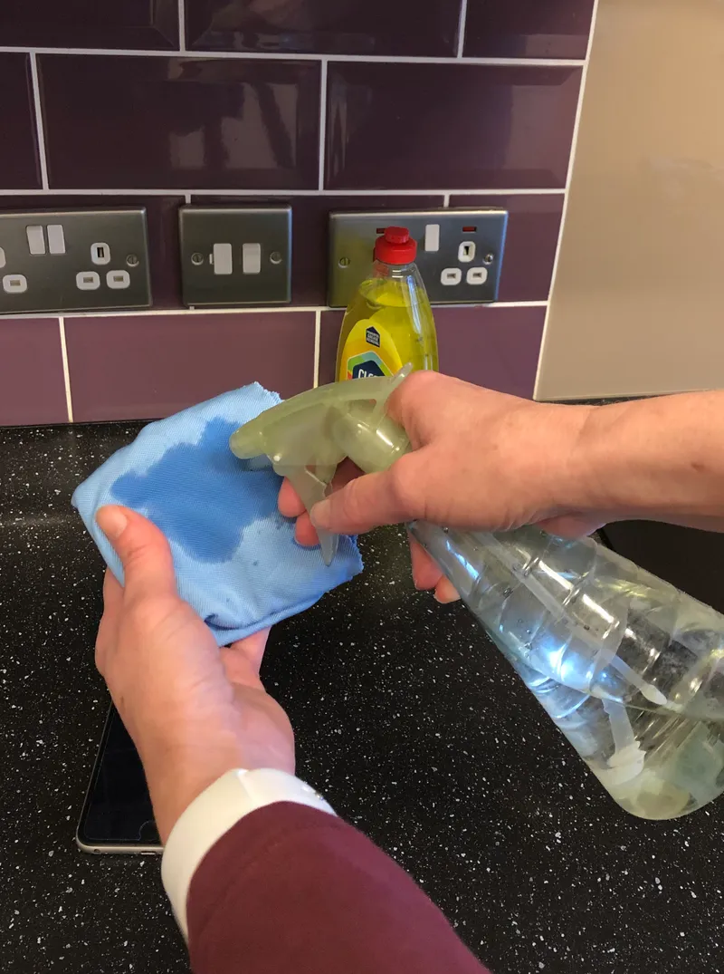 spraying a microfiber cloth with water