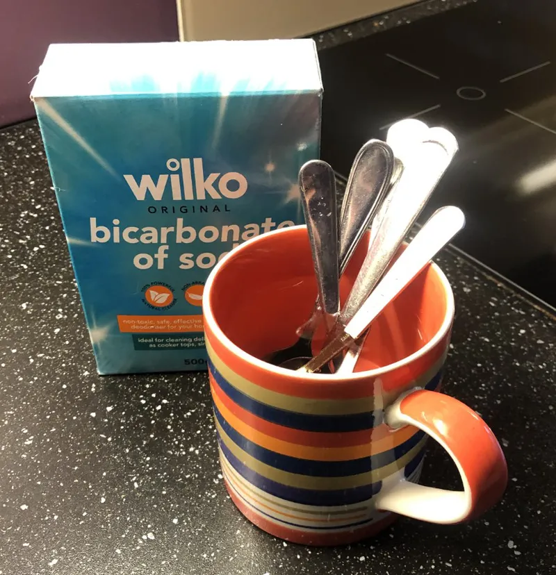 cleaning teaspoons in a mug of water