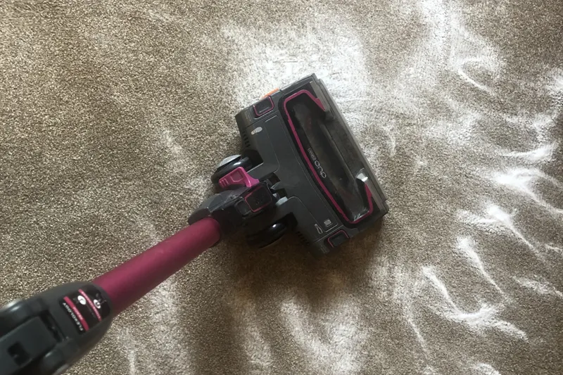 cleaning up baking soda from the carpet with a Shark Duoclean cordless vacuum