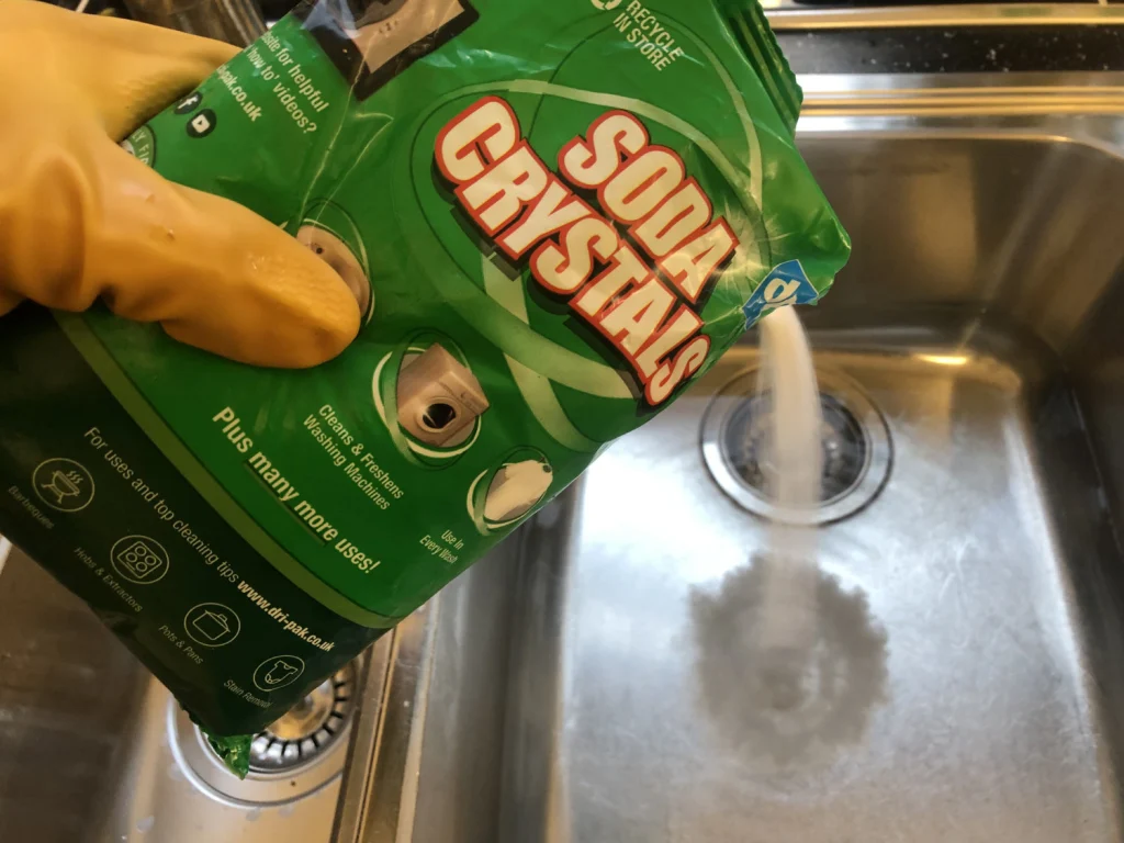 pouring soda crystals into the drain