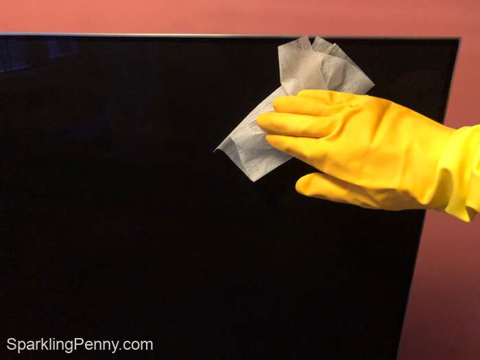 wiping a tv screen with a dryer sheet