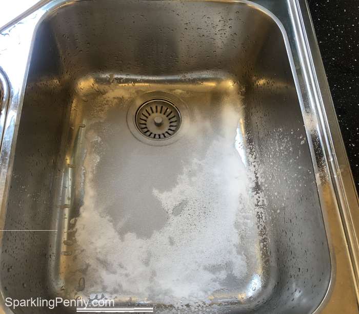 stainless steel sink covered in baking soda