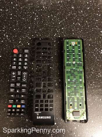 remote taken apart with the buttons showing along side the top cover