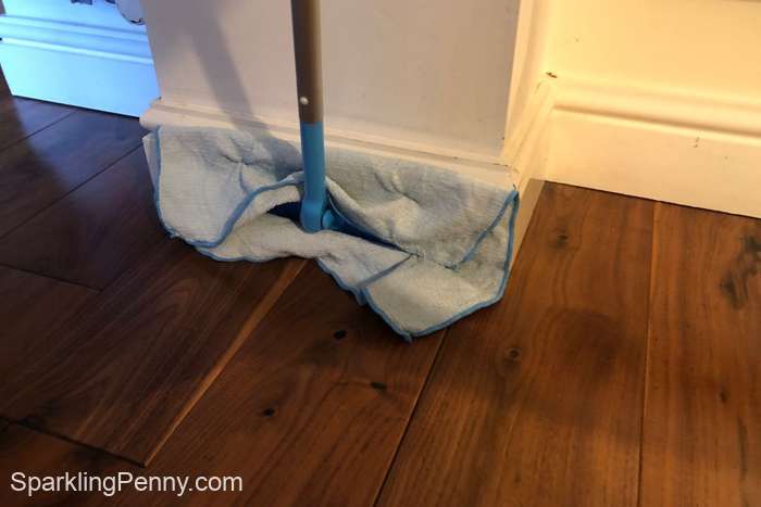 dusting baseboards with a microfiber cloth