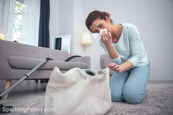 woman sneezing because she is not use the correct dusting techniques to clean dust without spreading it