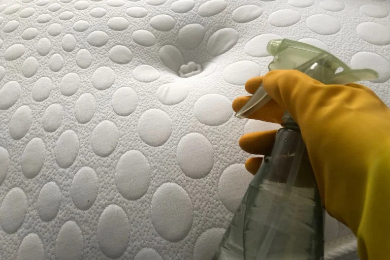 spraying a mattress with homemade dust mite spray